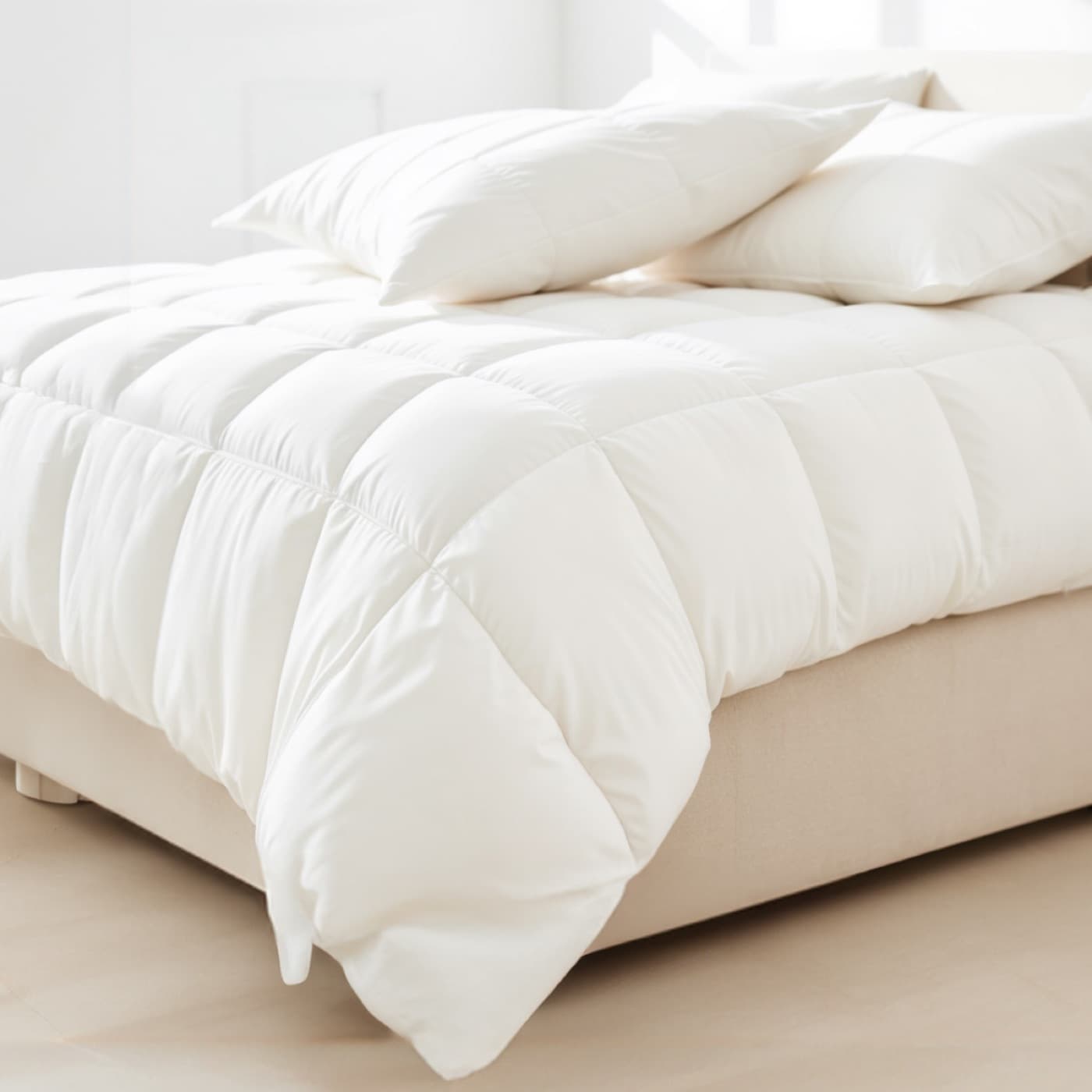 Weiße Steppbettdecke mit Kissen auf einem hellen Bett